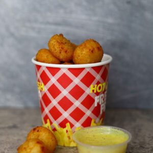a basket of Buttons with a yellow sauce