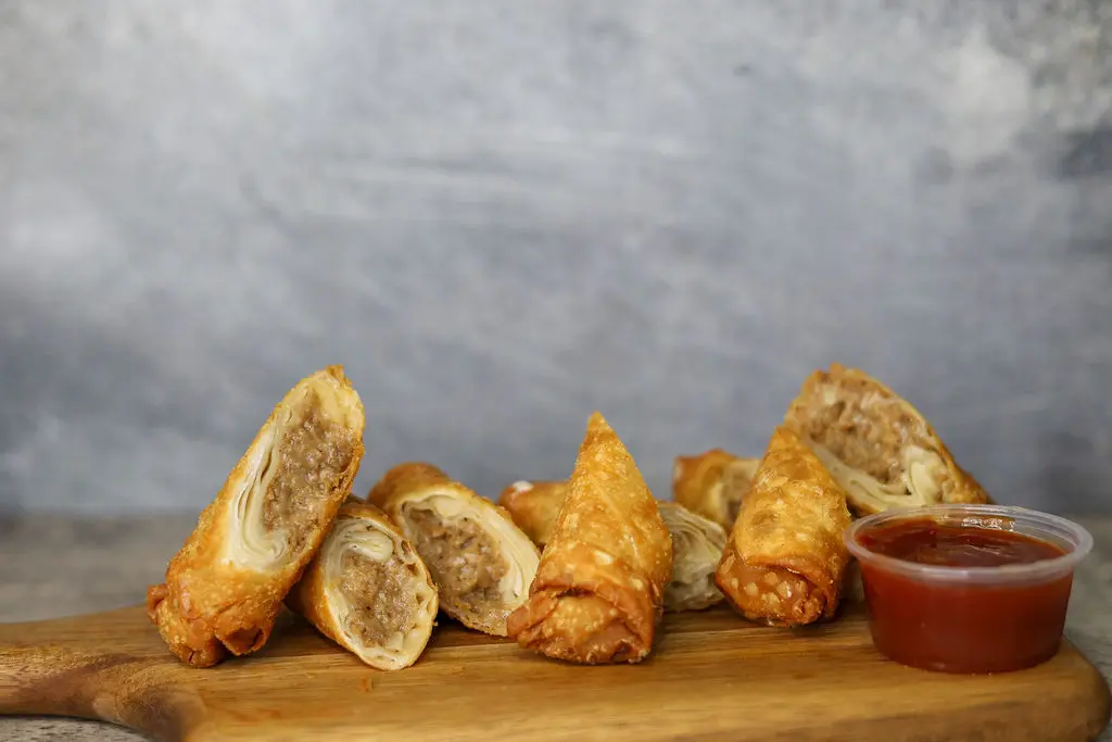 Cheese steak egg rolls with a red sauce