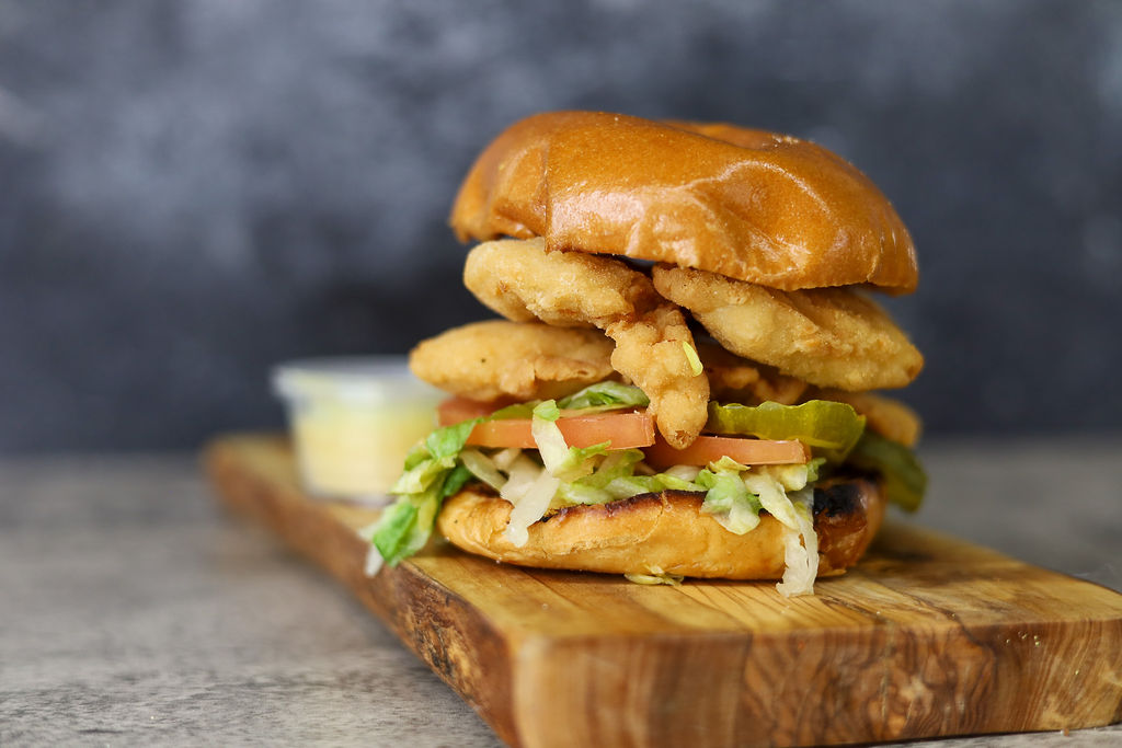 closeup shot of Chicken Tender Sandwich on a wooden platter